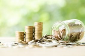 Coin on wooden table in front of green bokeh background. Coin on wooden table in front of green bokeh background. coins a concept of investment and saving moneys.
